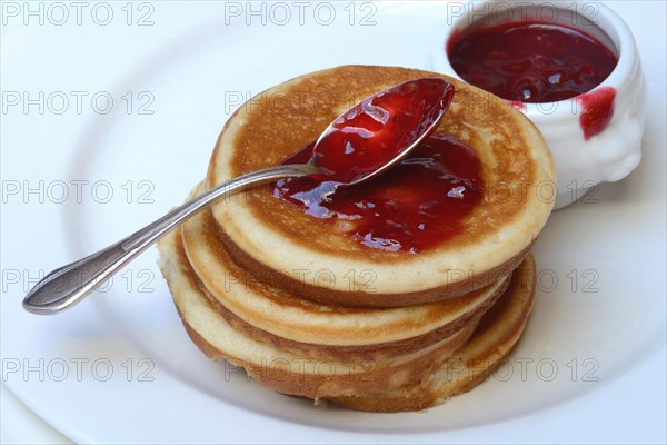 Pancake with raspberry jam and spoon