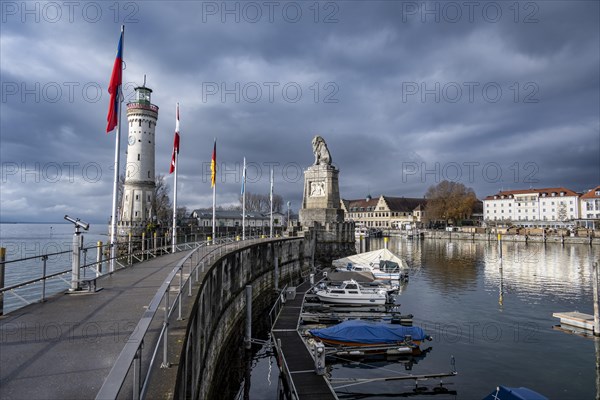 Lion pier with boats and Bavarian lion, in the back New Lindau lighthouse, Lindau harbour entrance, Lindau island, Lake Constance, Bavaria, Germany, Europe