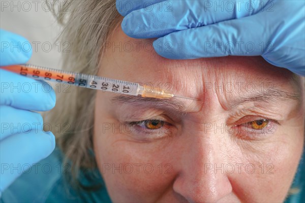 Senior woman getting skin care injection. Aged lady having botox injecting procedure. Cosmetic treatment with injection in a clinic