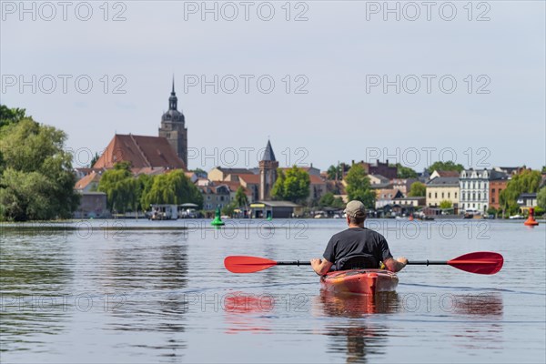 Paddlers in a kayak on the Havel, with St. Catherines Church in the background, Brandenburg an der Havel, Brandenburg, Germany, Europe