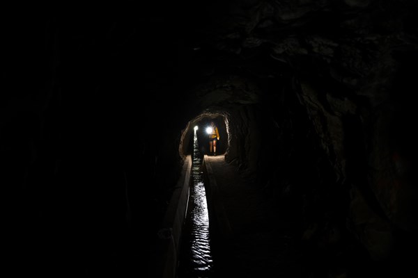 Hiker in a tunnel at Levada do Moinho, Ponta do Sol, Madeira, Portugal, Europe