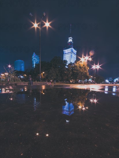 Night cityscape with reflections in the puddle