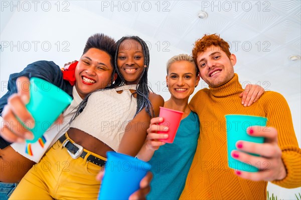 LGBT pride, lgbt rainbow flag, portrait of group of friends dancing and toasting with glasses in a house at party