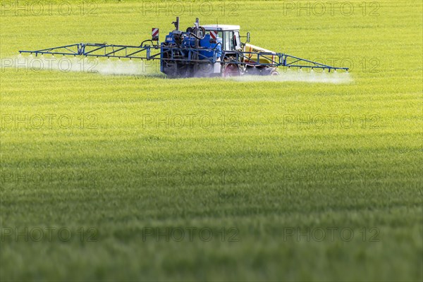 Farmer with tractor fertilising his field, Dornstadt, Baden-Wuerttemberg, Germany, Europe