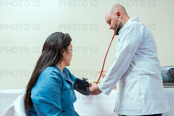 Measuring blood pressure to patient in the office, Nutritionist man measuring blood pressure to female patient in office, Nutritionist measuring blood pressure to patient