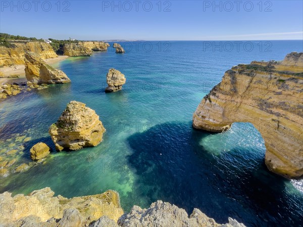 Beautiful cliffs and rock formations by the Atlantic Ocean at Marinha Beach in Algarve, Portugal, Europe