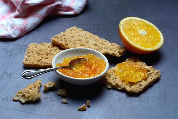 Orange marmalade in small bowls and on crispbread