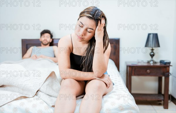 Wife on the edge of the bed arguing with her husband. Upset woman arguing with her husband in bed. Concept of couple problems in bed