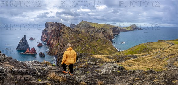 Hiker, coastal landscape, cliffs and sea, Miradouro da Ponta do Rosto, rugged coastline with rock formations, Cape Ponta de Sao Lourenco, Madeira, Portugal, Europe