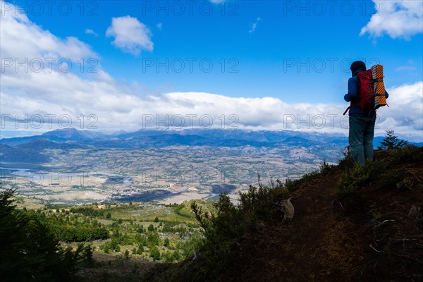 Hikers climbing to the lagoon on Cerro Castillo mountain, with the river valley of the Rio Ibanez in the background, Cerro Castillo National Park, Aysen, Patagonia, Chile, South America