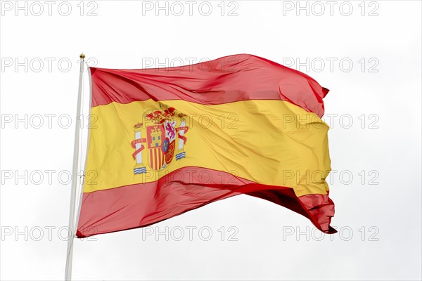 Flag of spain waving in the wind with cloudy sky in the background
