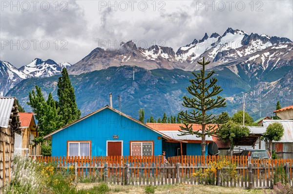 Blue wooden house, Cerro Castillo mountain range in the back, Villa Cerro Castillo village, Cerro Castillo National Park, Aysen, Patagonia, Chile, South America