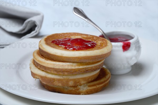 Pancake with raspberry jam and spoon