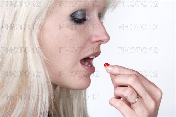 Woman holding a painkiller between finger