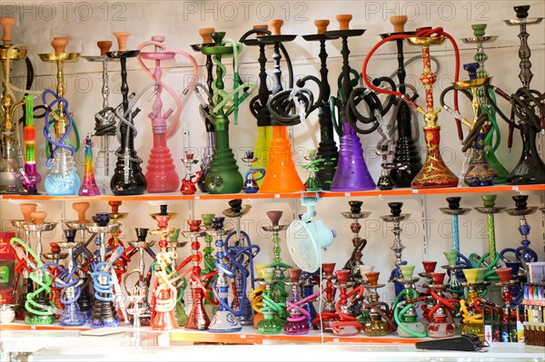 Group of eastern hookahs placed of various colors on a shelf