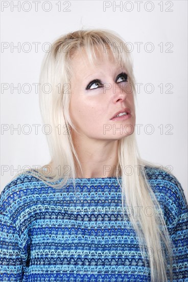 Portrait of young blond woman thinking and looking somewhere up