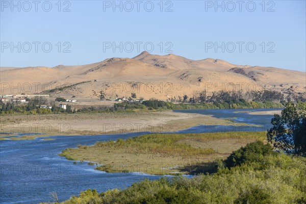 Orange River, also known as the Orange River, on the border between Namibia and South Africa, sand dunes behind, Oranjemund, Sperrgebiet National Park, also known as Tsau ÇKhaeb National Park, Namibia, Africa