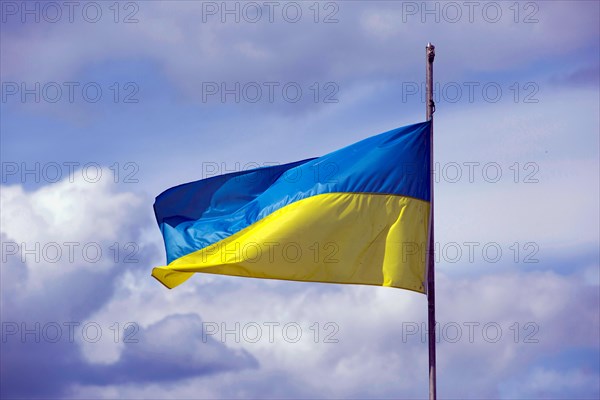 Ukrainian national flag on a pole waving in the wind, Berlin, Germany, Europe
