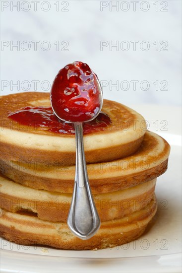 Pancake with raspberry jam and spoon