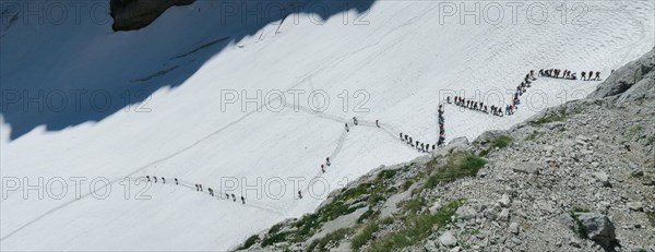 View from above on people walking on the zigzag glacier. Big queue, congestion. Zugspitze massif in the bavarian alps, Dolomites, Italy, Europe