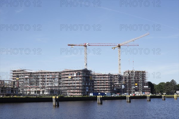 Modern residential building on the Hunte, construction site, construction cranes, new building, Oldenburg in Oldenburg, Lower Saxony, Germany, Europe