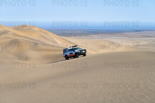 Off-road vehicle in sand dunes above the Orange River, also Oranjemund, Sperrgebiet National Park, also Tsau ÇKhaeb National Park, Namibia, Africa