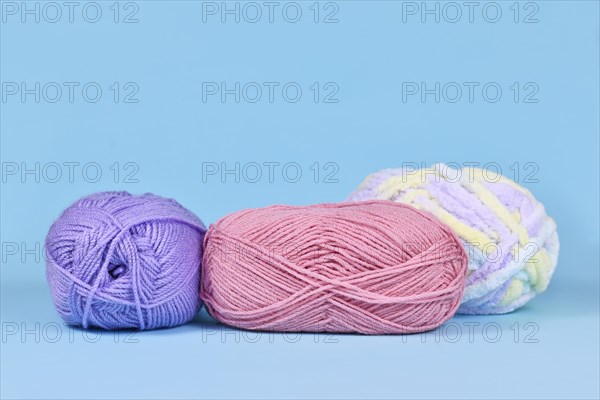 Balls of wool on pastel blue background