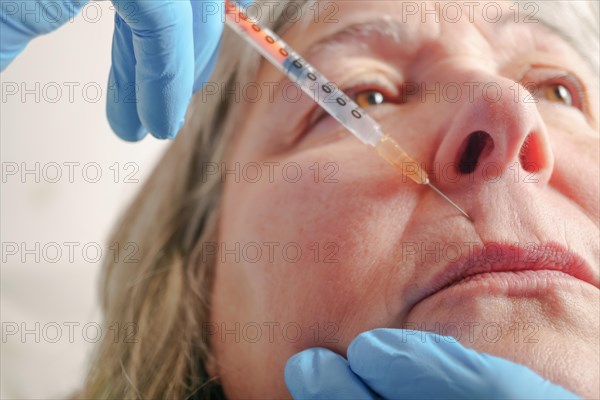 Older woman injected in lips Hyaluronic acid, Woman in beauty salon. plastic surgery clinic