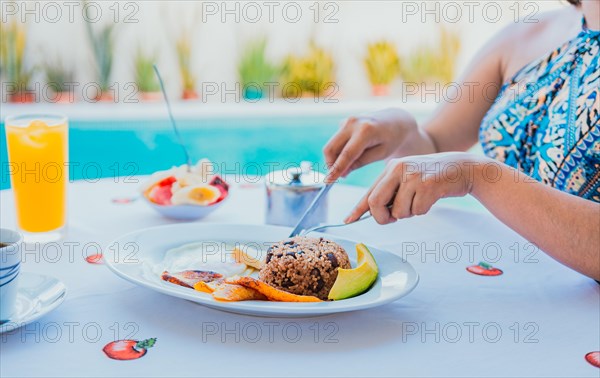 Breakfast near the swimming pool. hands of girl with a breakfast near the pool