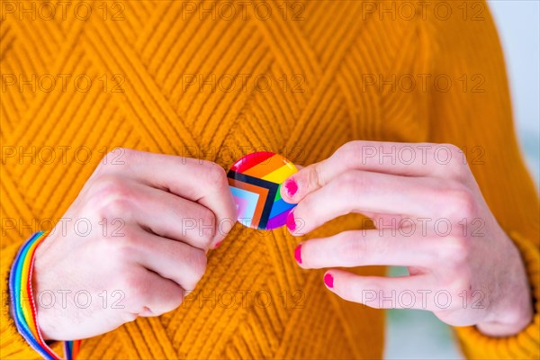 Metal badge with lgbt flag on lapel of man or woman suit