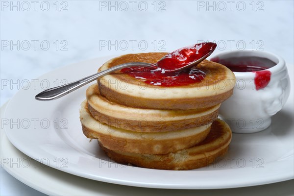 Pancake with raspberry jam and spoon