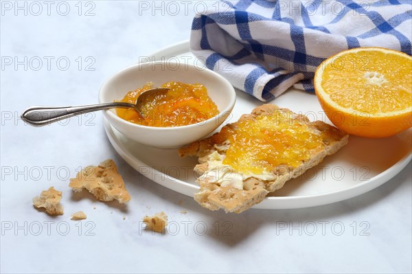 Orange marmalade in small bowls and on crispbread