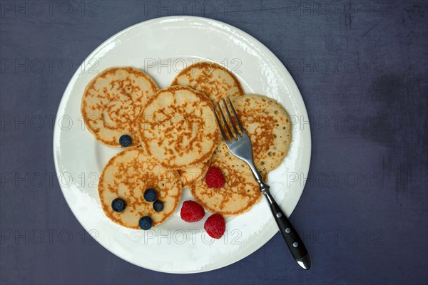 Blini, blinis on plate with fruit, mini pancakes