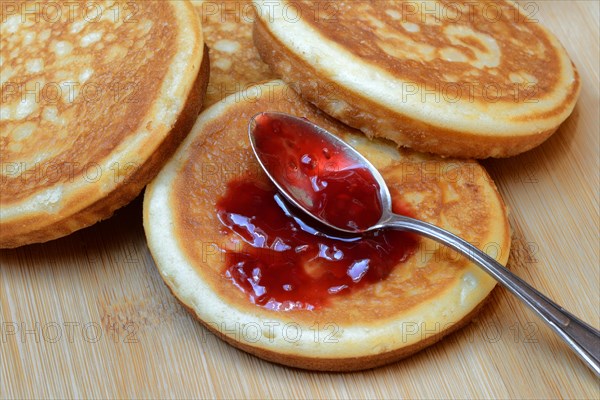 Pancake with raspberry jam and spoon