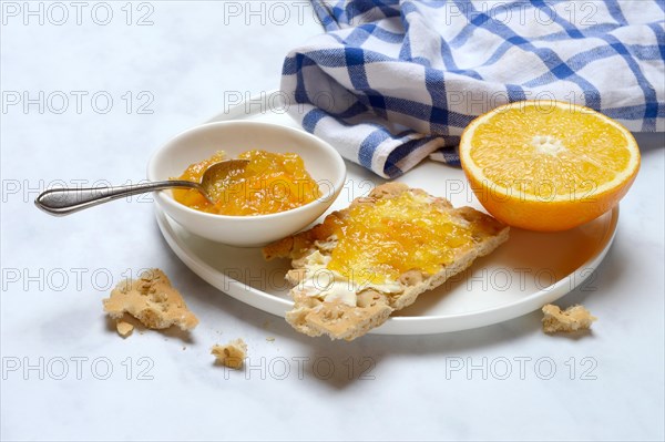 Orange marmalade in small bowls and on crispbread