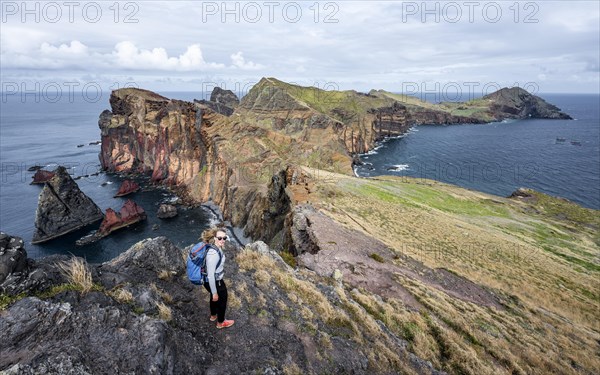 Hiker, coastal landscape, cliffs and sea, Miradouro da Ponta do Rosto, rugged coastline with rock formations, Cape Ponta de Sao Lourenco, Madeira, Portugal, Europe