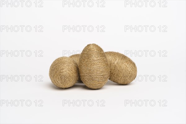 Hand wrapped easter eggs with jute twine, isolated white background. Studio