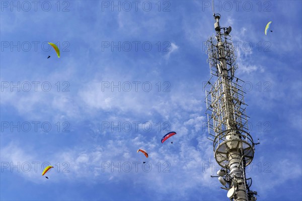 Paragliders flying over Mount Mercury with transmitter mast in Baden-Baden, Black Forest, Baden-Wuerttemberg, Germany, Europe