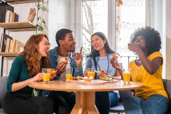 Friends at a breakfast with orange juice and muffins at home, together to celebrate good news