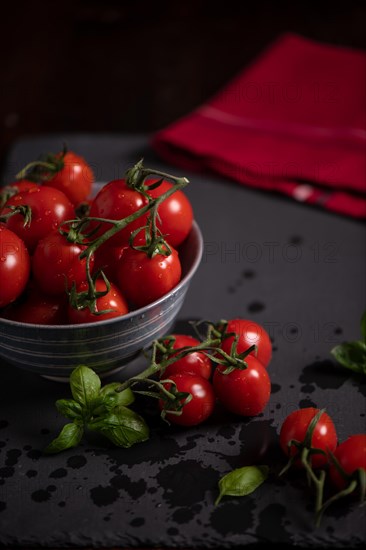 Red tomatoes in bowl on slate, fitness, cooking, vegetarian, vegan, vitamins, cultivation, healthy, close up, several, kitchen towel