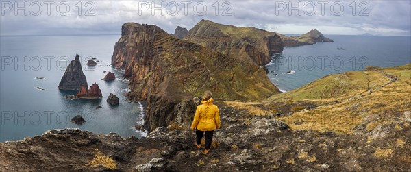 Hiker, coastal landscape, cliffs and sea, Miradouro da Ponta do Rosto, rugged coastline with rock formations, Cape Ponta de Sao Lourenco, Madeira, Portugal, Europe