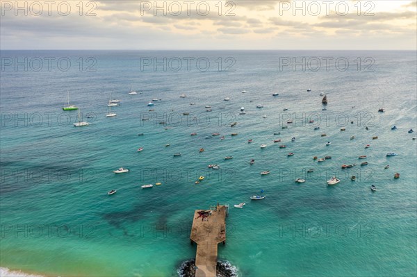 Pier and boats on turquoise water in city of Santa Maria, island of Sal, Cape Verde, Africa