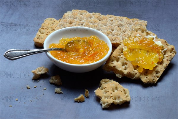 Orange marmalade in small bowls and on crispbread