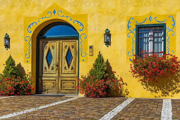 Ornate and flower-decorated house entrance, Cortina dAmpezzo, Dolomites, South Tyrol, Italy, Europe