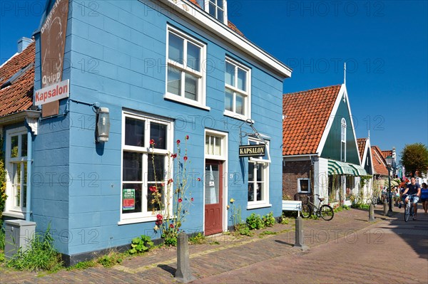 Den Burg, Texel, Netherlands, August 2019: Hairdresser and barber shop in beautiful traditional Dutch blue building in side street of city Den Burg on island Texel