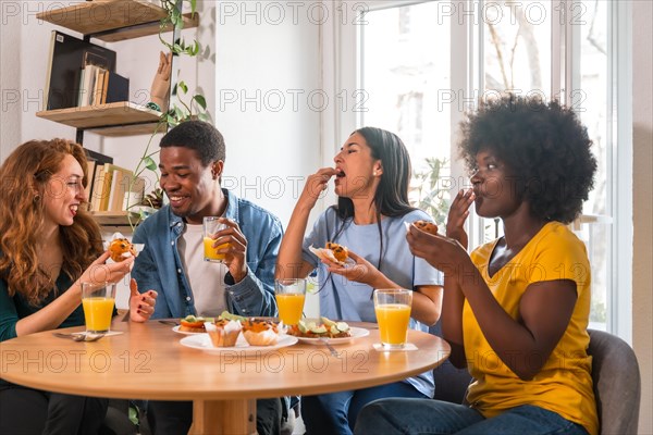 Friends at a breakfast with orange juice and muffins at home, healthy lifestyle having fun in the morning