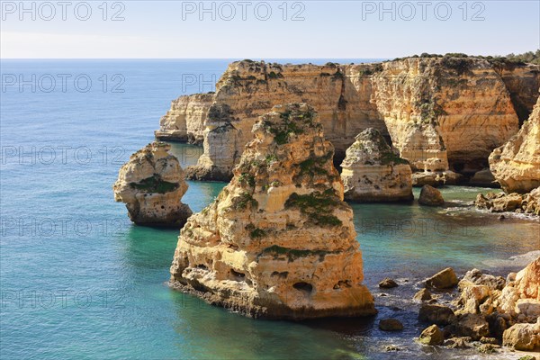 Beautiful cliffs and rock formations by the Atlantic Ocean at Marinha Beach in Algarve, Portugal, Europe