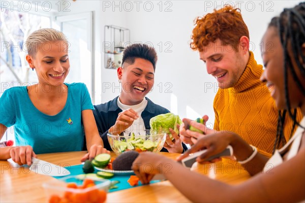 Portrait of a group of friends preparing vegetarian food. Preparing the salad and having fun around the house