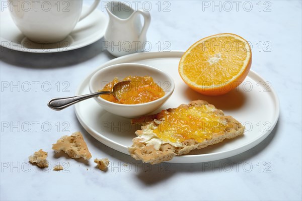 Orange marmalade in small bowls and on crispbread