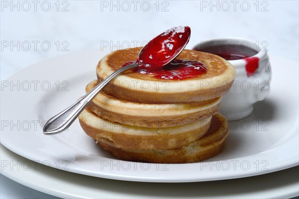 Pancake with raspberry jam and spoon